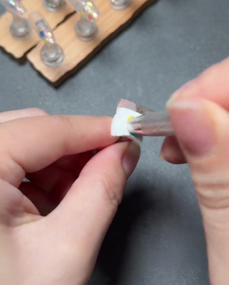 A small brush dabbing light pink gel to create a smooth gradient from the cuticle down the nail.