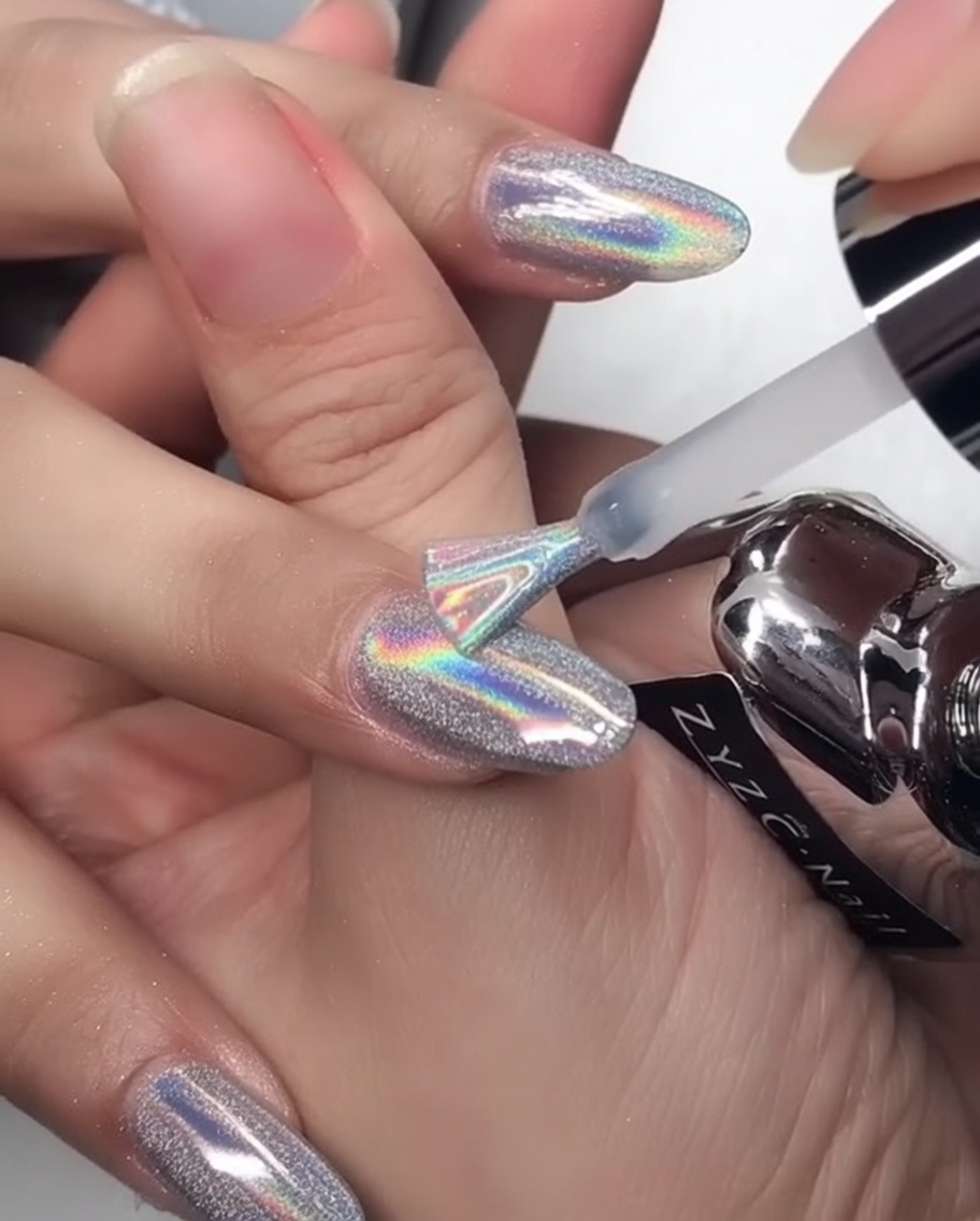 A hand placed inside an LED nail lamp, with light illuminating the fingers during the curing process.