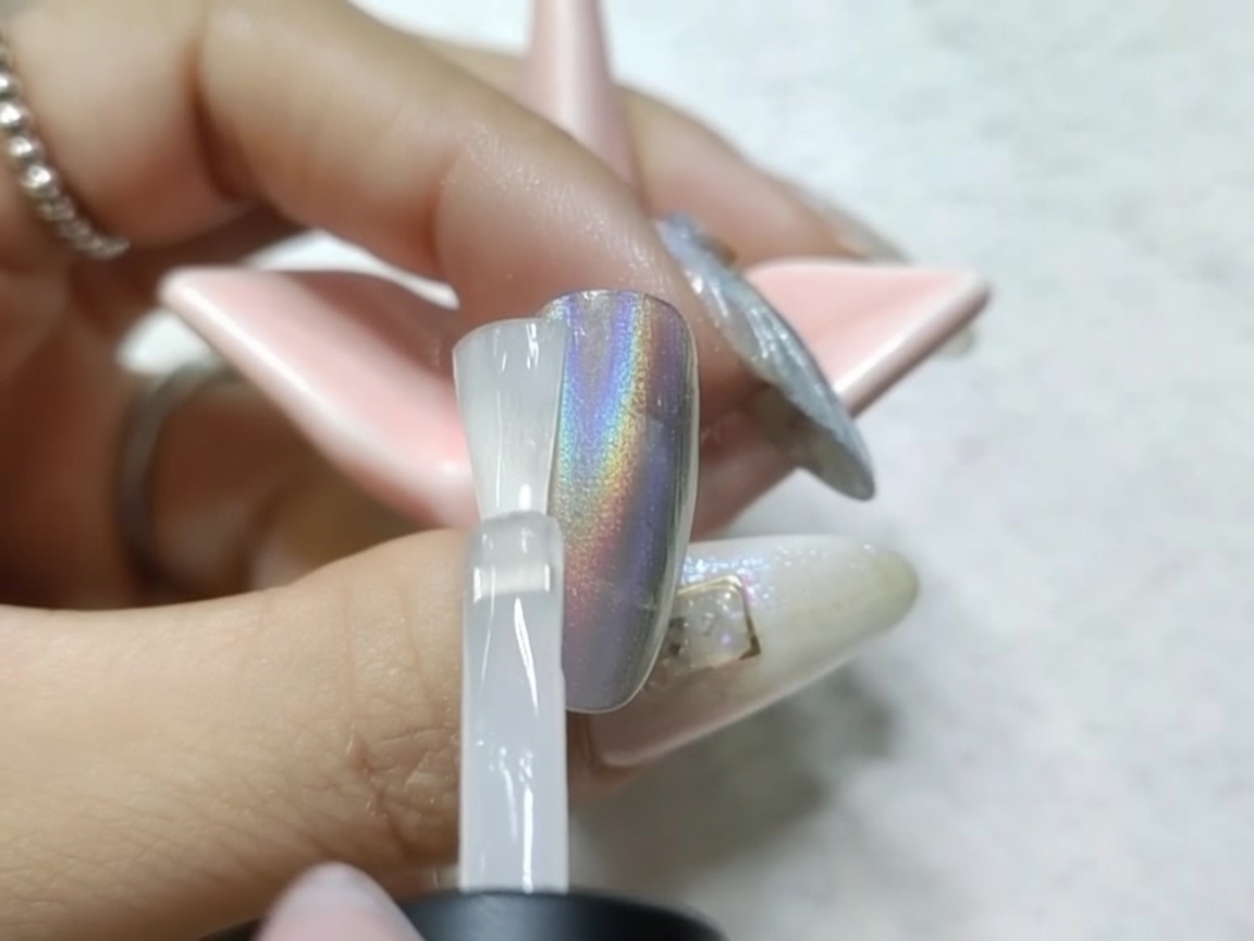 A chrome-finished nail curing under the UV/LED lamp after the matte top coat application.