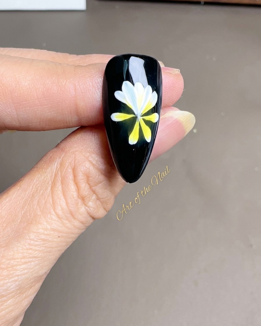 A fine liner brush adding crisp, white petals over an existing yellow and white floral base.