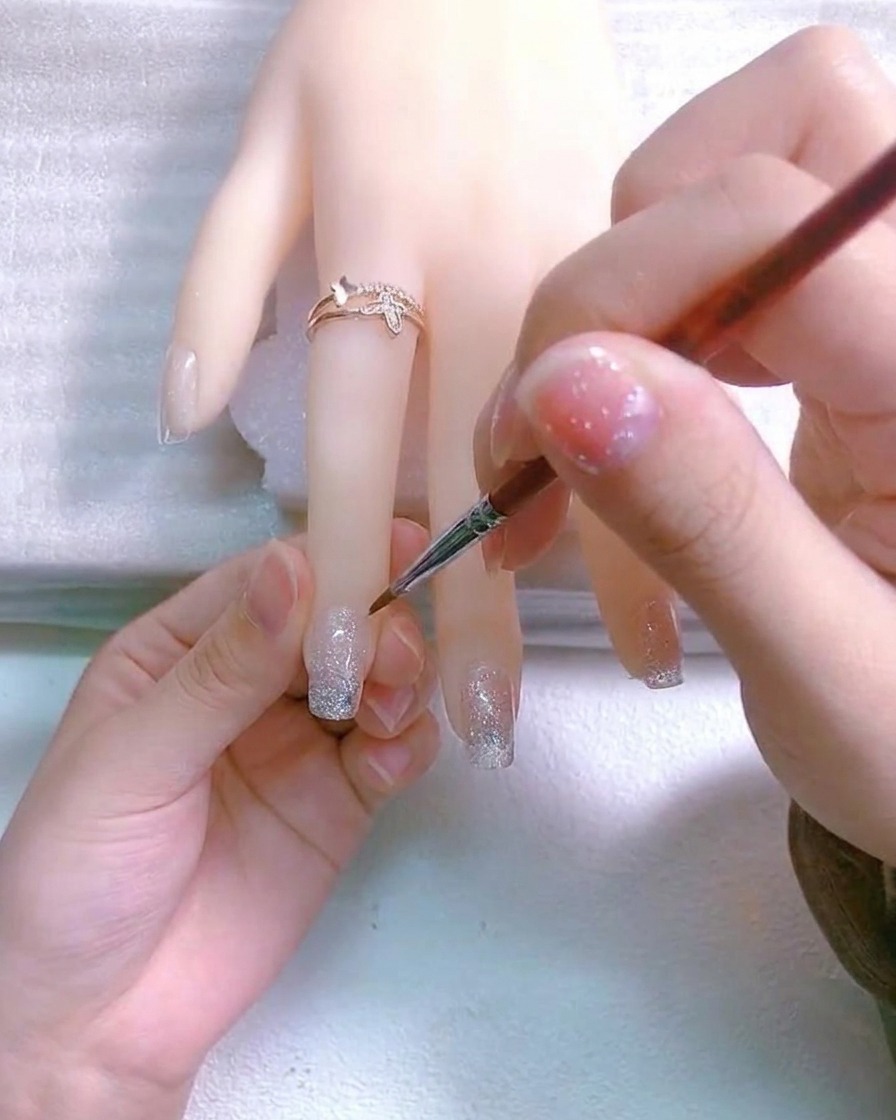 A small white cross drawn with a fine detail brush on the nail surface.