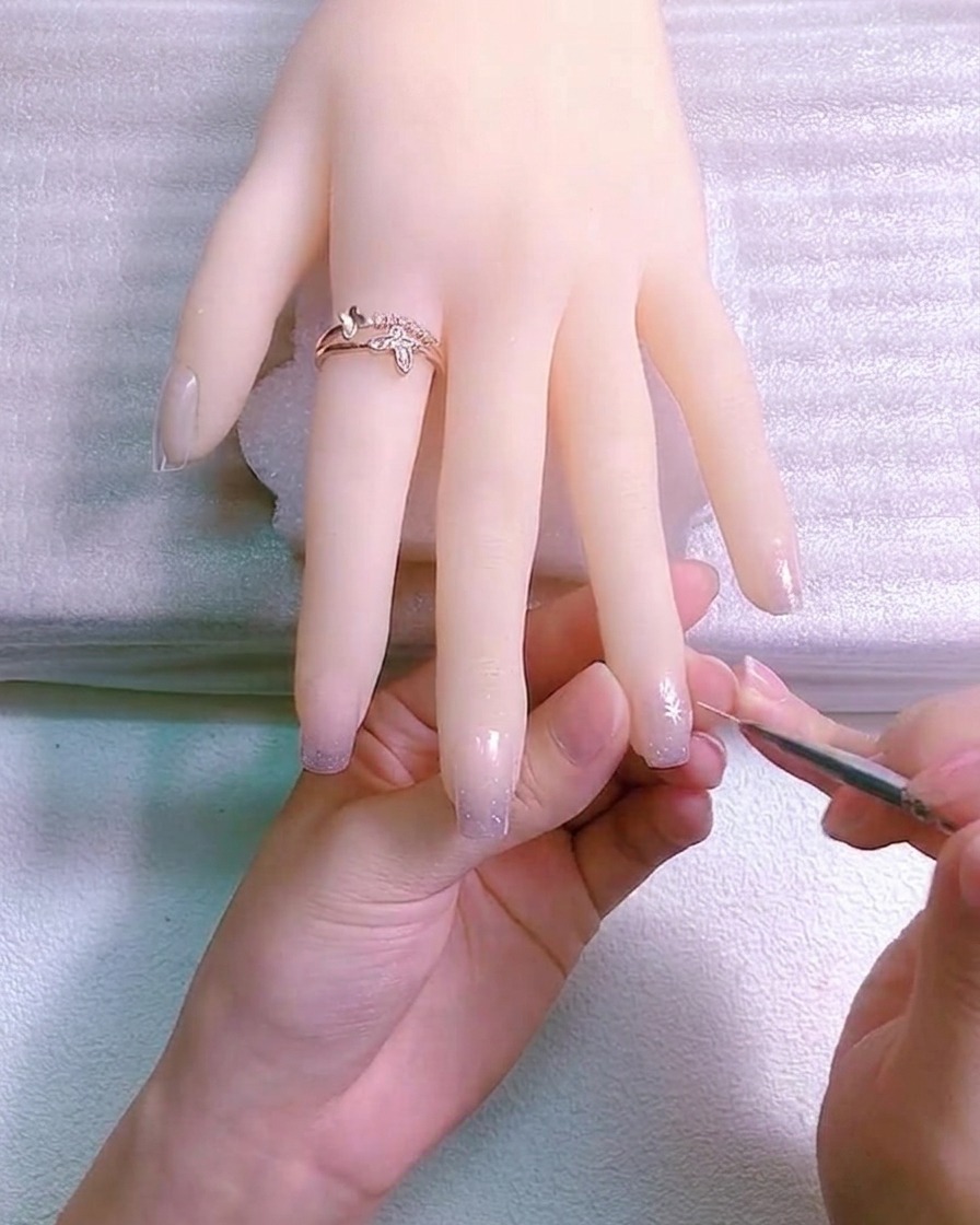 A white daisy flower with rounded petals painted onto the nail.