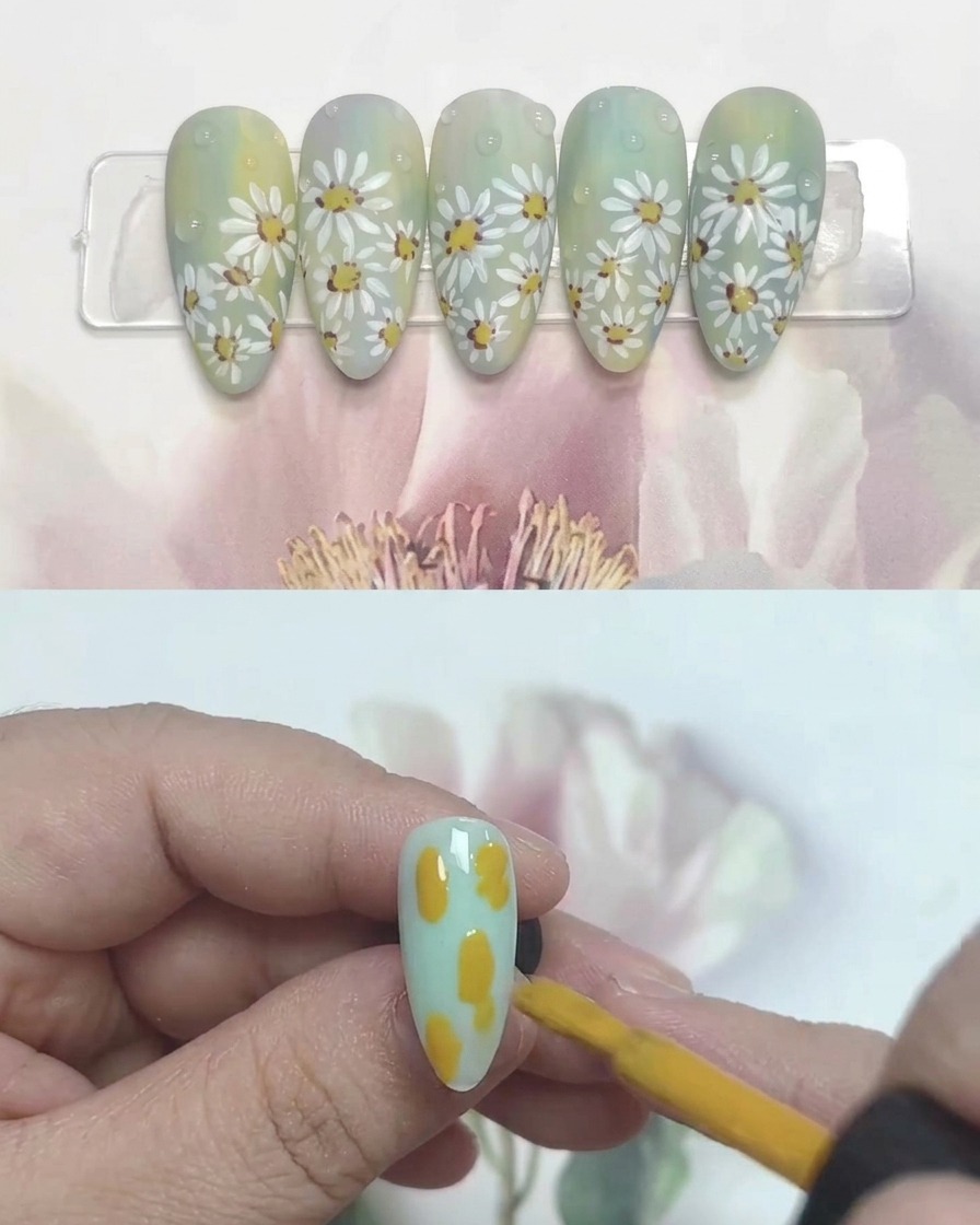 A nail brush applying blobs of yellow, blue, and white gel onto a clear nail tip.