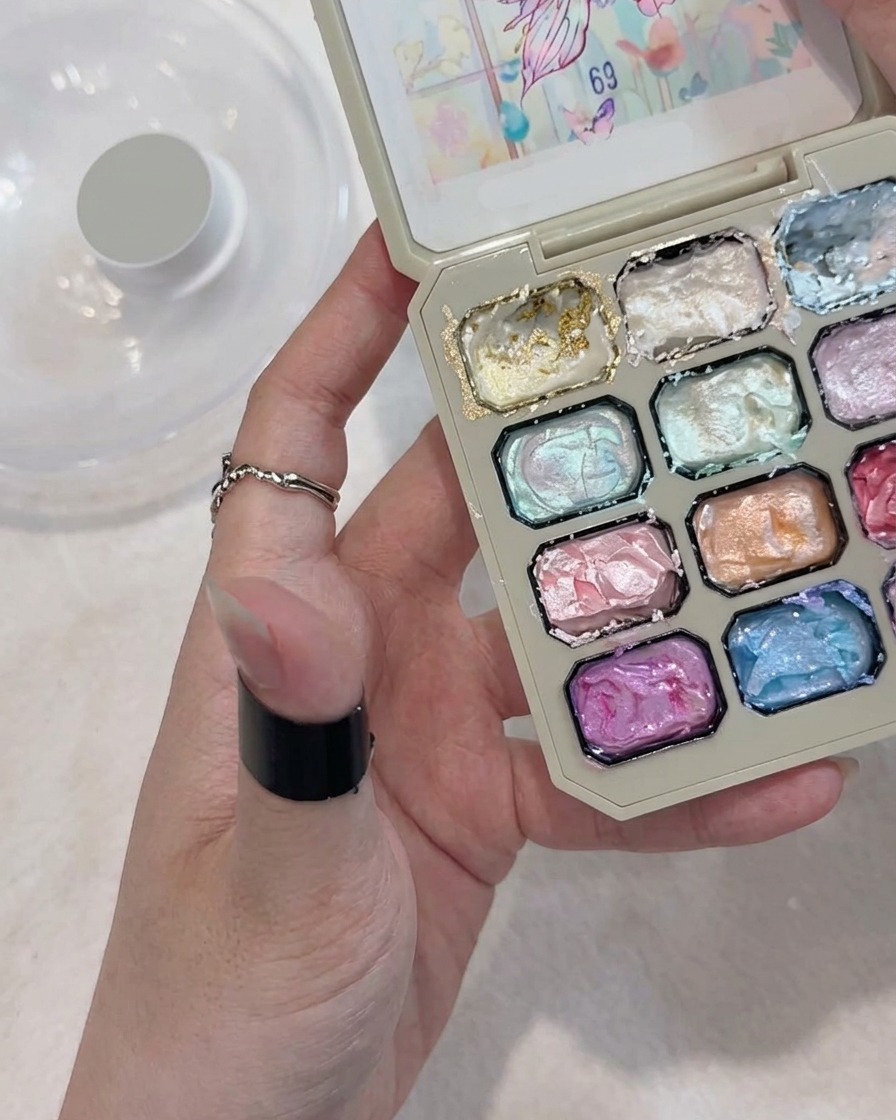 A brush applying white gel to form a five-petaled flower shape on a nail.