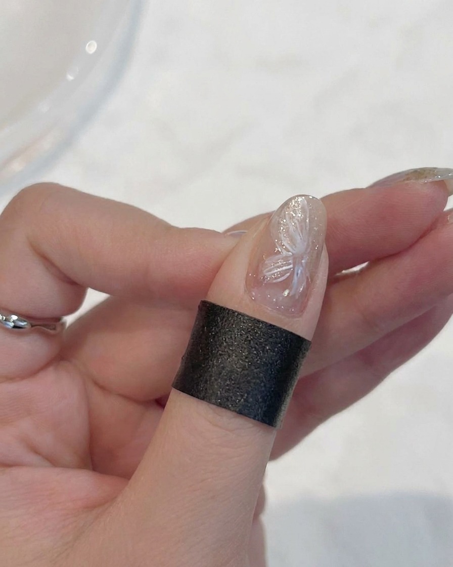A brush layering a thin, milky white gel over the existing flower petals.