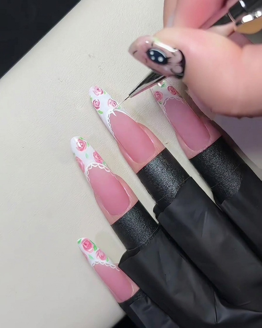 A detailed view of a finished lace border design on a nail, featuring tiny semi-circles and dots applied with a precision brush.
