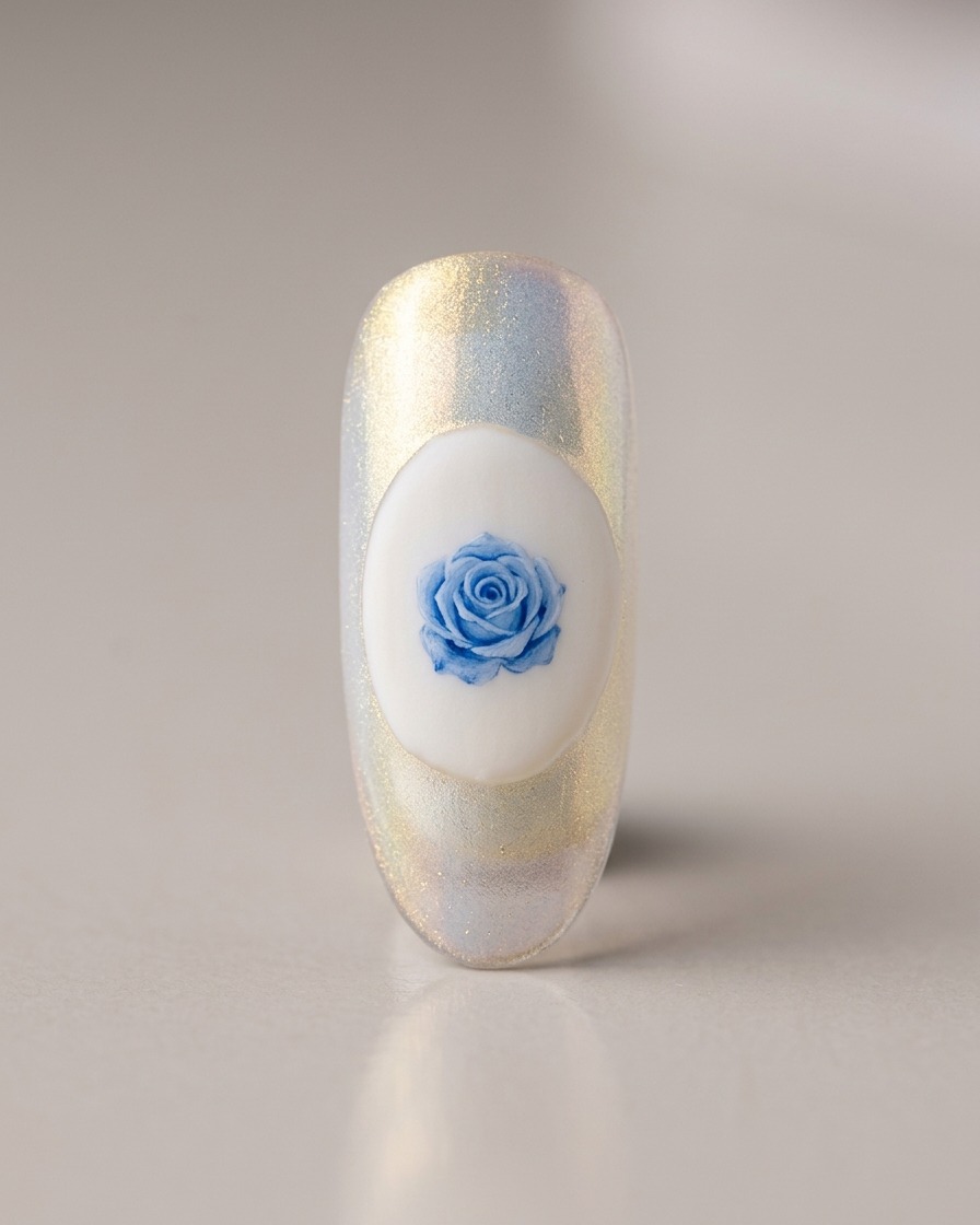 A fine liner brush detailing a small, light blue rose design on a solid white oval base on a nail.