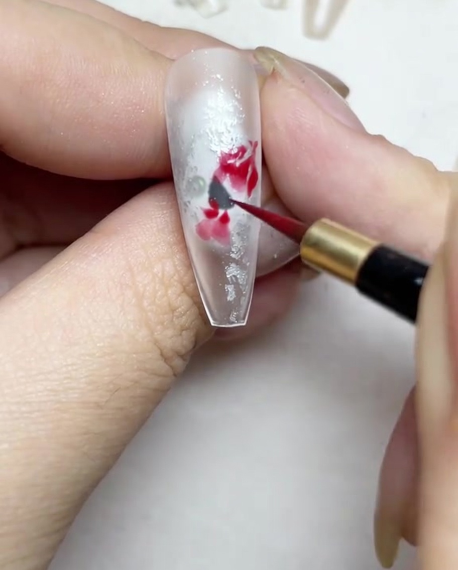 Deepening the center of the watercolor rose with a darker shade of red.