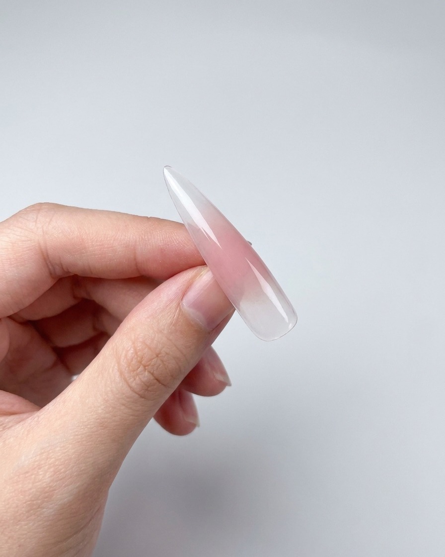 A close-up of a nail tip with magnetic gel, showing a shimmer effect created by a magnet held nearby.