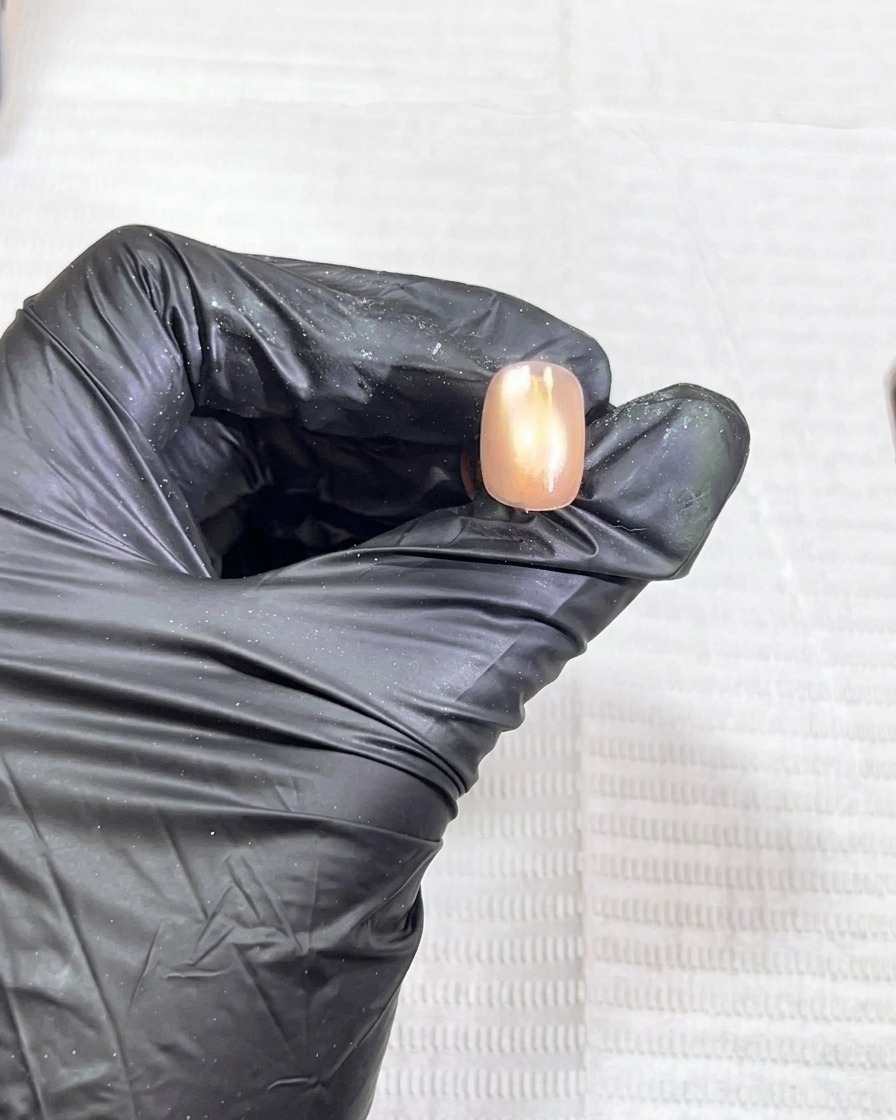 The nail being placed into a UV lamp for the curing process.
