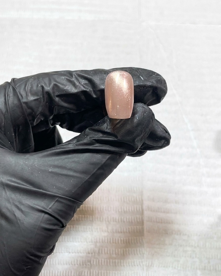 The nail curing under the UV lamp light for the 120-second cycle.