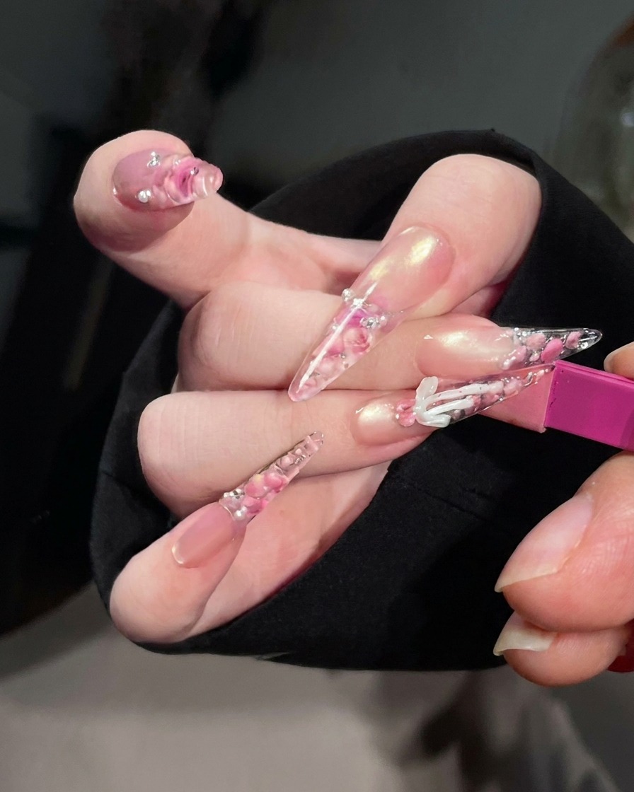 A close-up view of nails inside a UV/LED nail lamp with the light on, indicating the curing process.