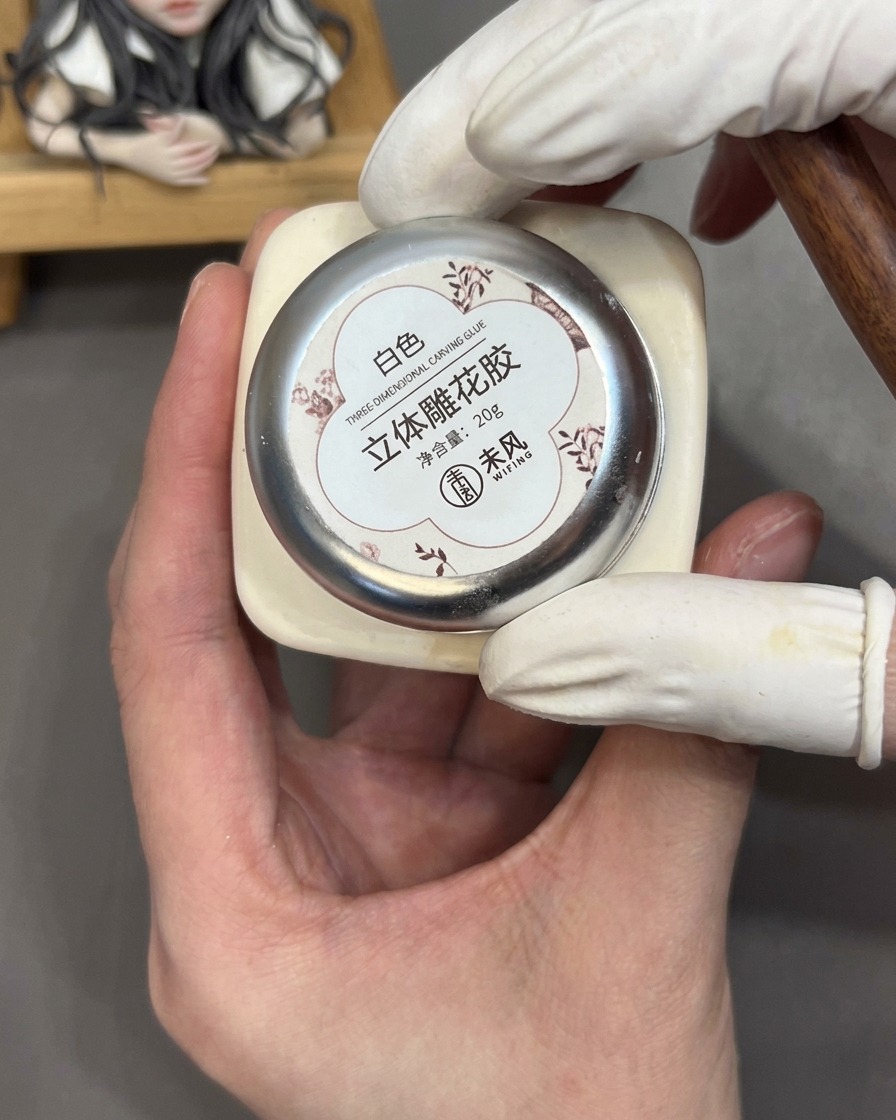 A tool holding a small bead of white 3D sculpting gel against a palm to prepare it for petal formation.