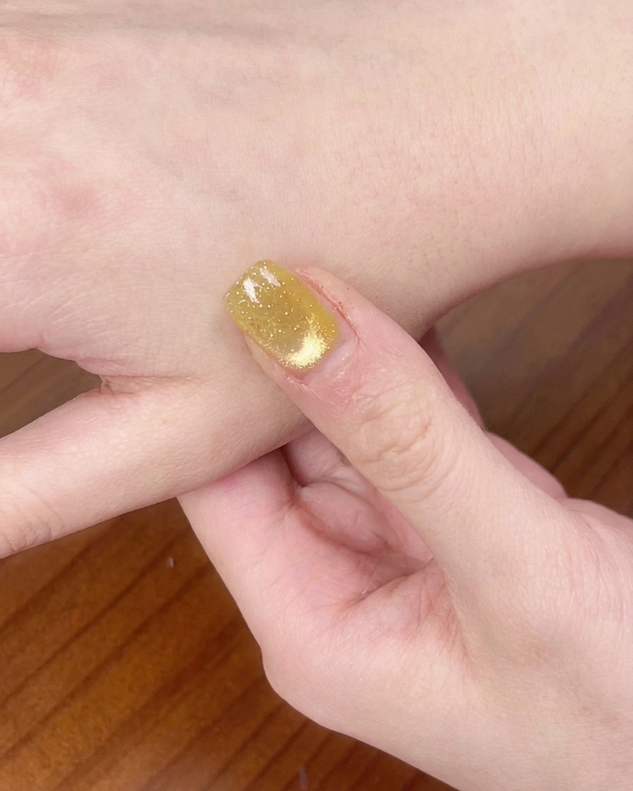A hand resting inside a UV/LED nail lamp curing the gel polish.