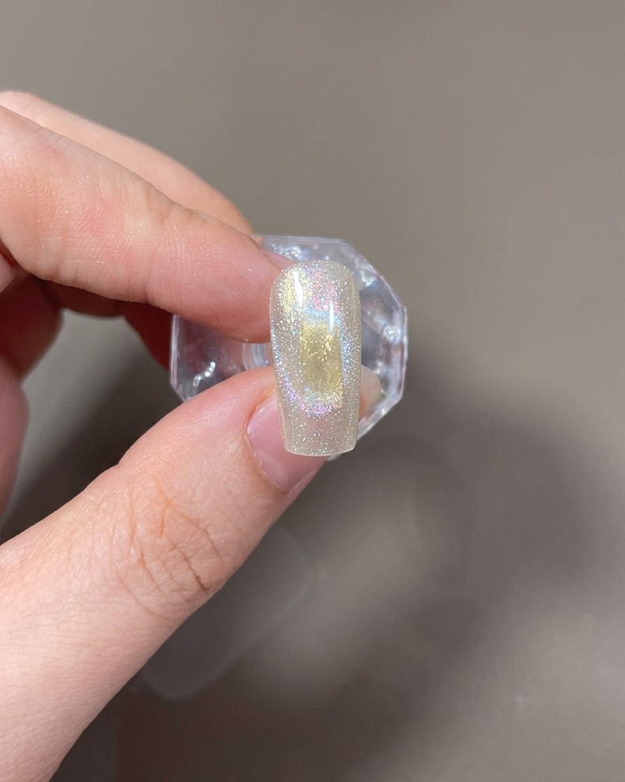 A rectangular magnet held horizontally next to the nail to form a wide cat-eye light.
