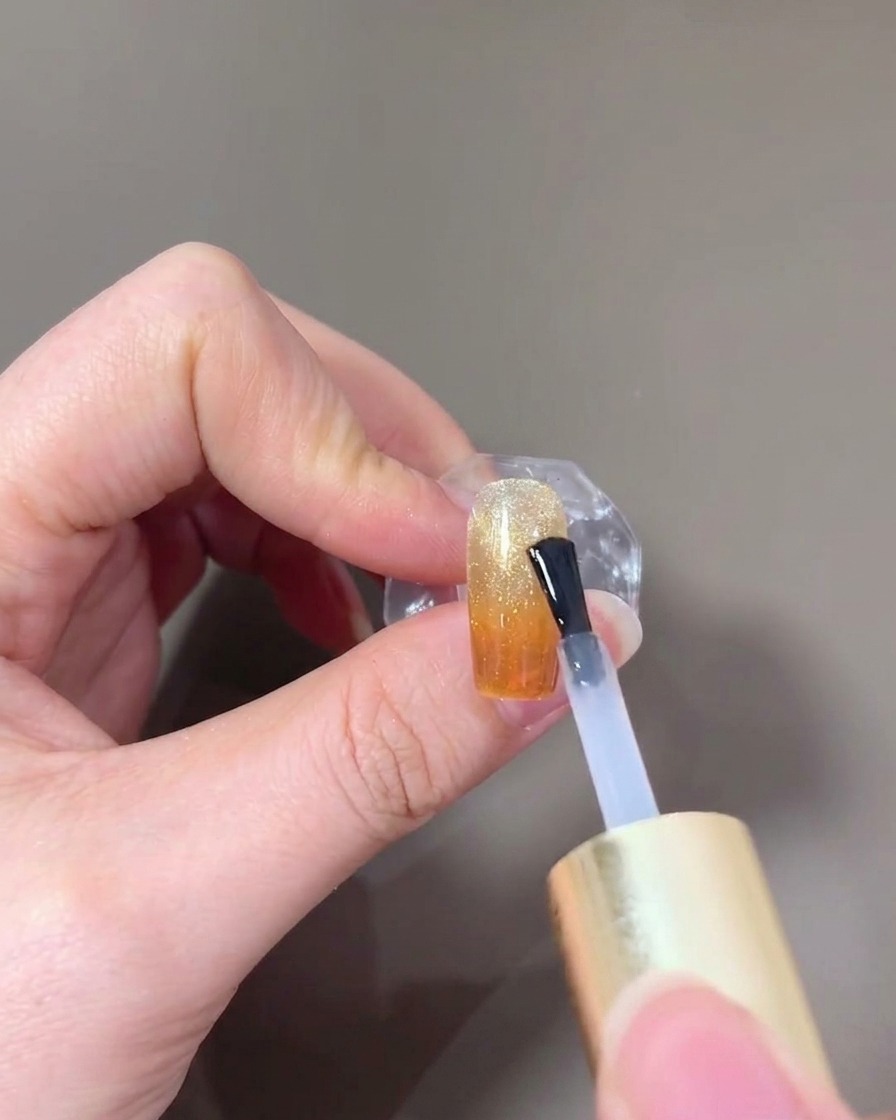 The finished nail being cured under a lamp.