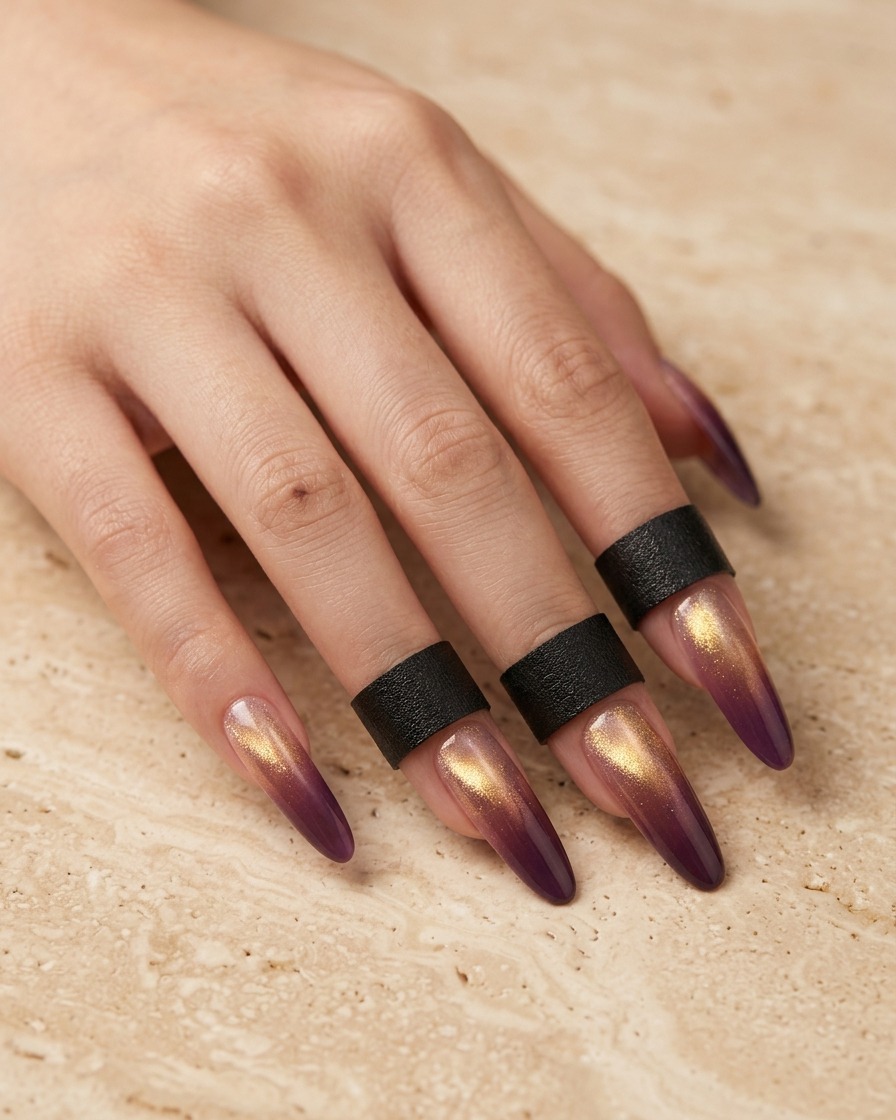 A close-up view of a brush applying a thin layer of purple gel polish to the tip of a clear, almond-shaped nail extension.