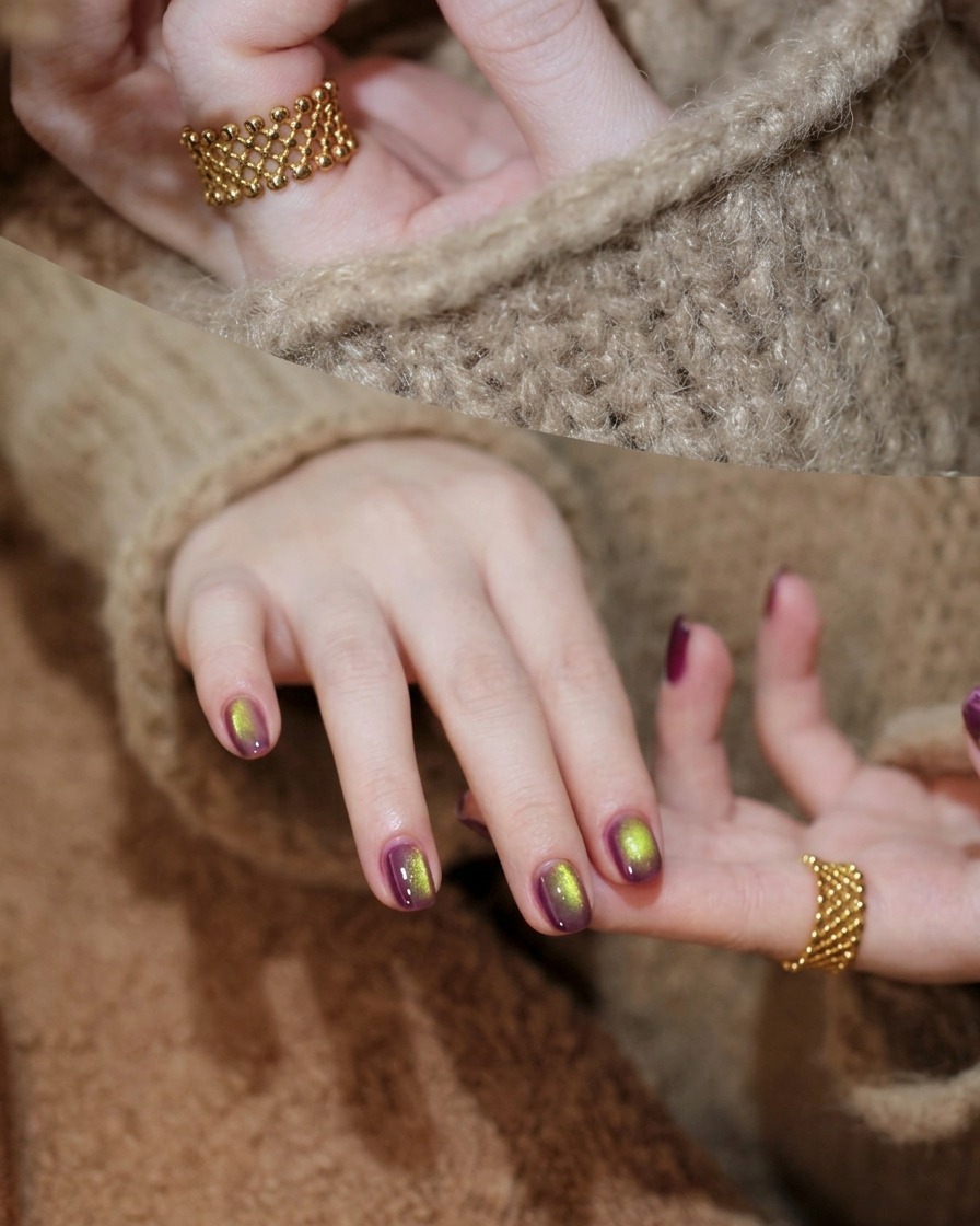A brush applying purple cat-eye gel polish over a cured purple base layer.