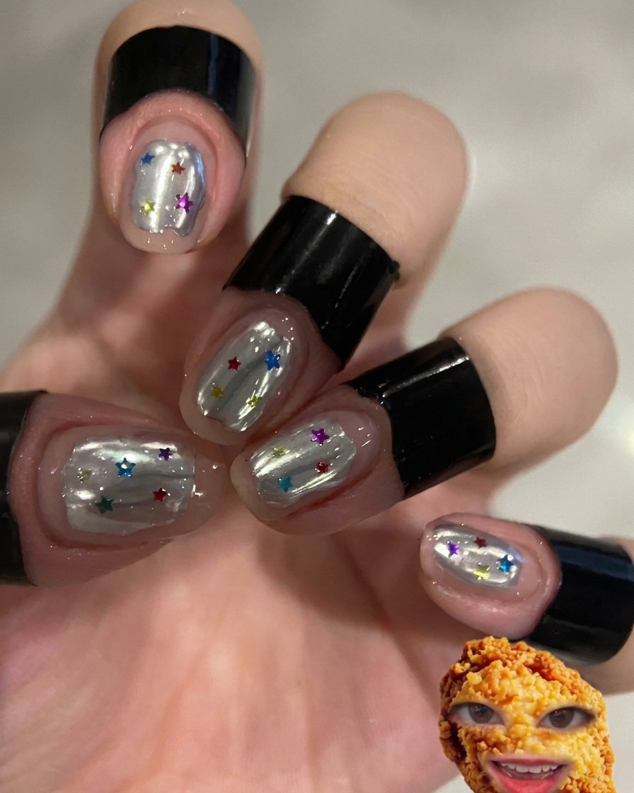 A brush applying a clear top coat to nails with a white wave design.
