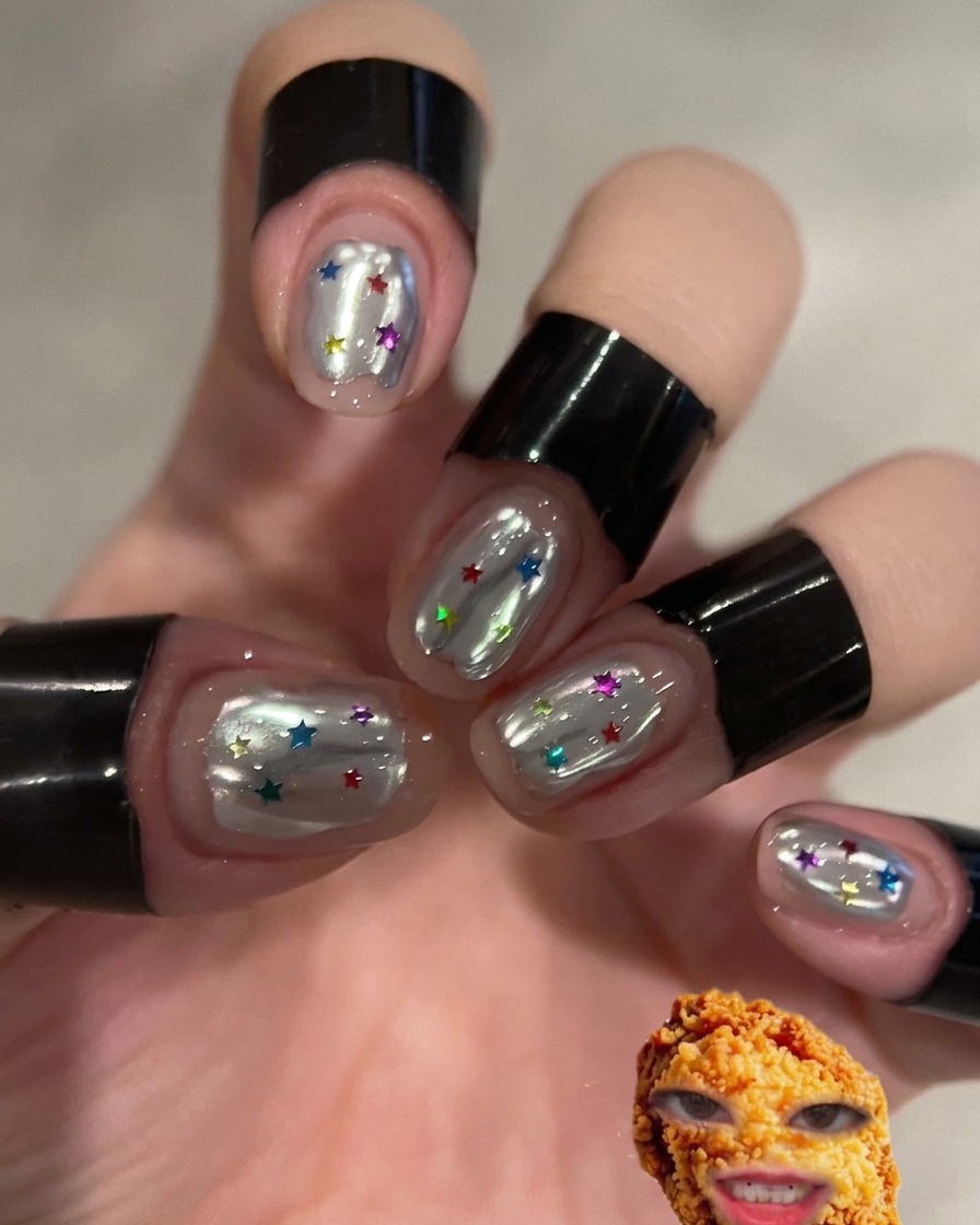A finger rubbing silver chrome powder onto a prepped nail surface.