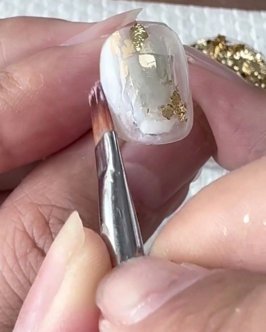 A fine brush softly blending the white gel into the blooming liquid.