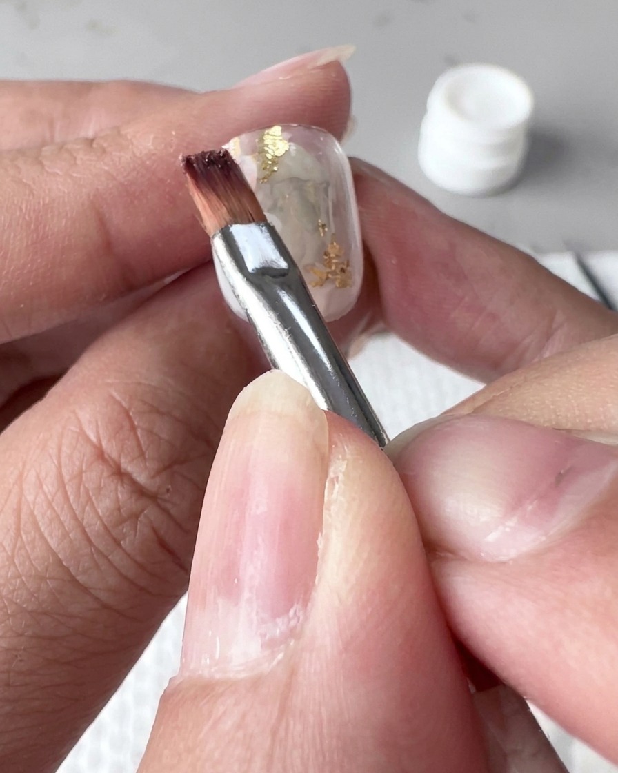 A nail positioned under a professional UV lamp during the curing process.
