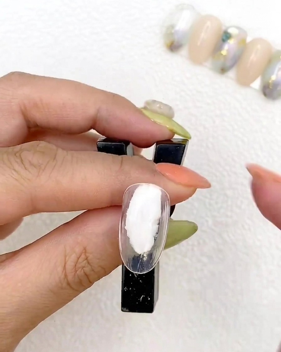 A nail tip being cured under a UV lamp.