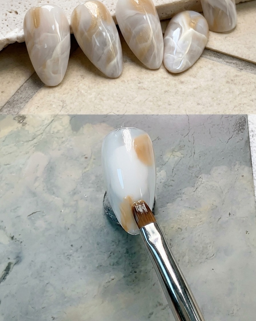 A close-up of a nail with a brown gel dab applied to the upper right section.