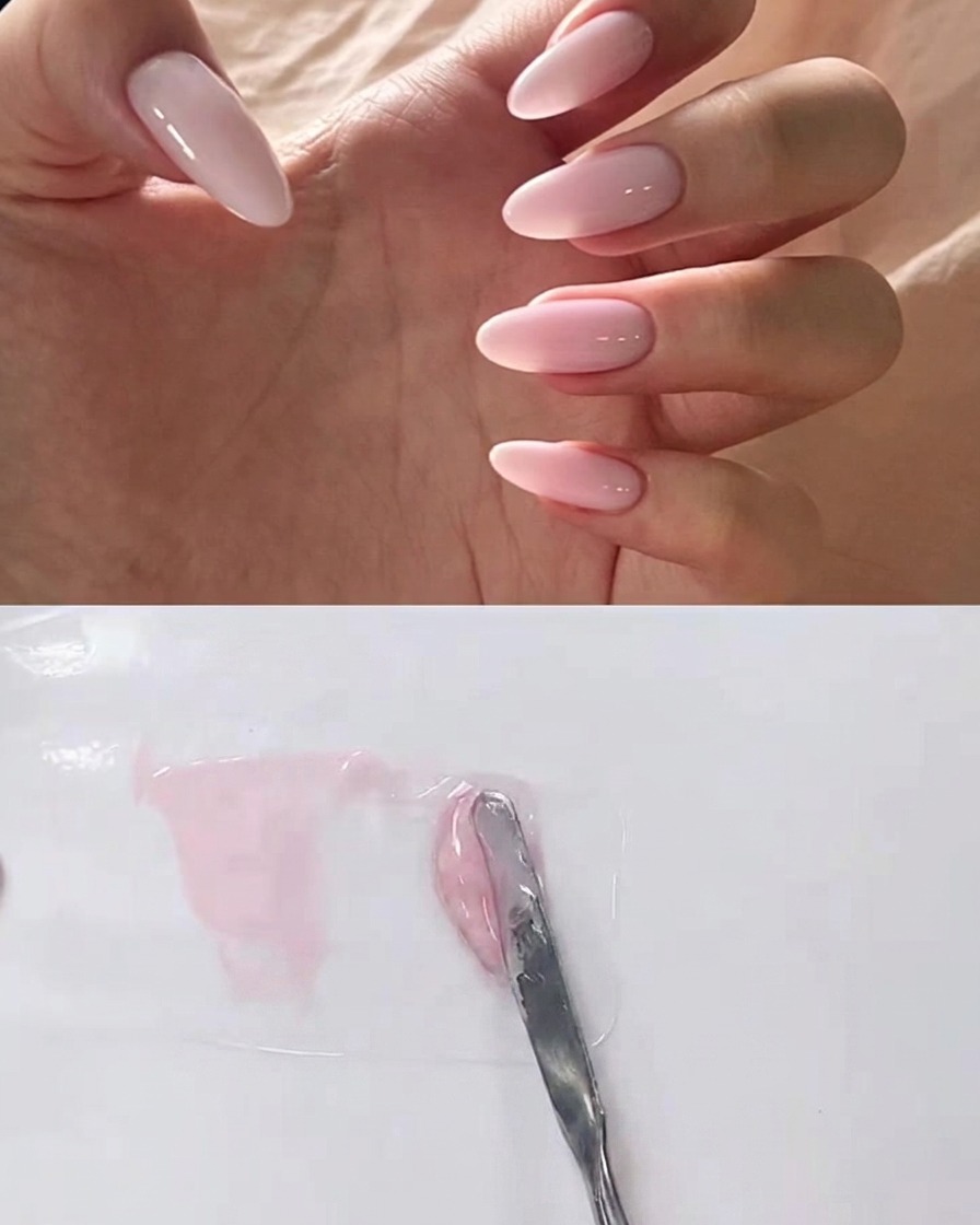 A metal spatula blending clear gel into a pink gel mixture on a mixing palette.