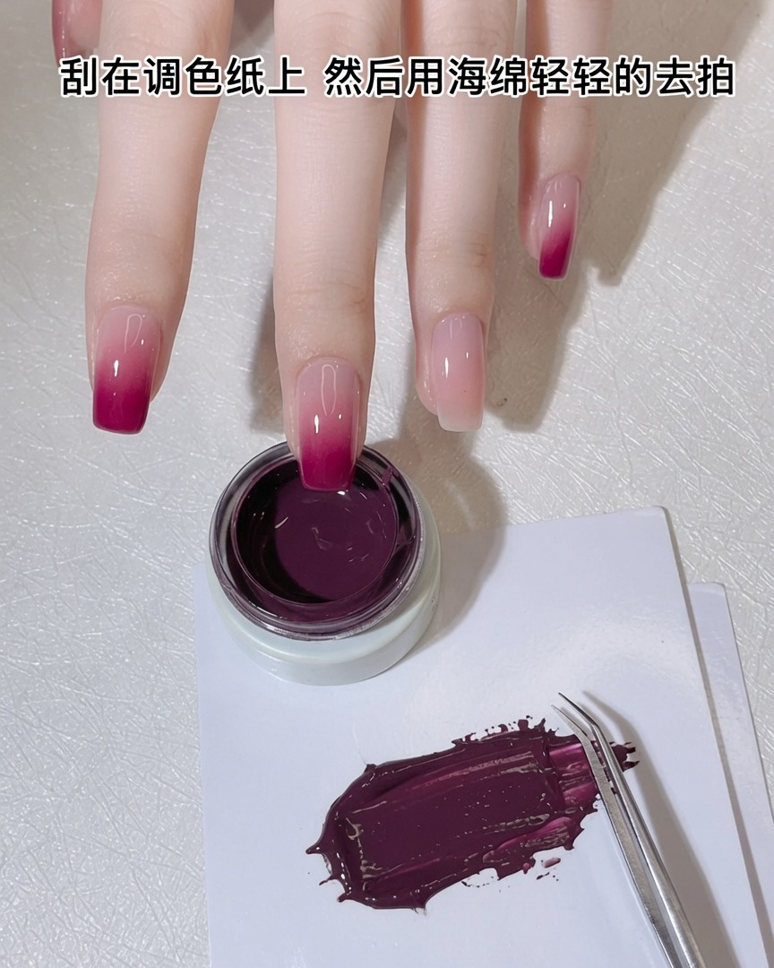 A white makeup sponge being pressed into a thin layer of purple-pink gel on a palette.