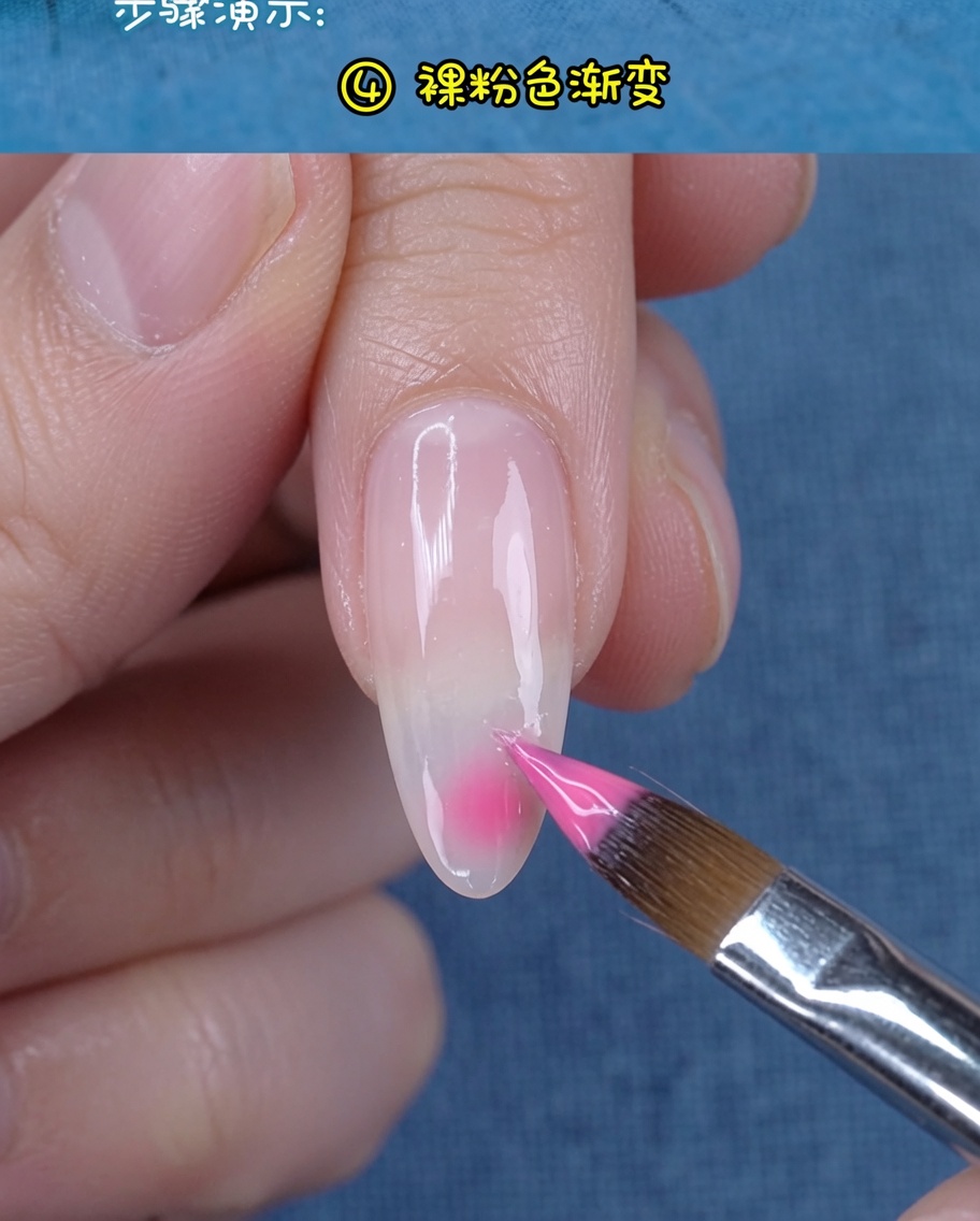 A soft nude-pink gel being applied to the tip of the nail to enhance the gradient.