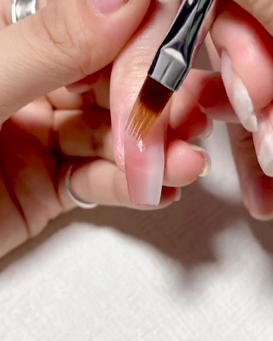 Close-up of a brush being wiped clean on a white lint-free cloth.