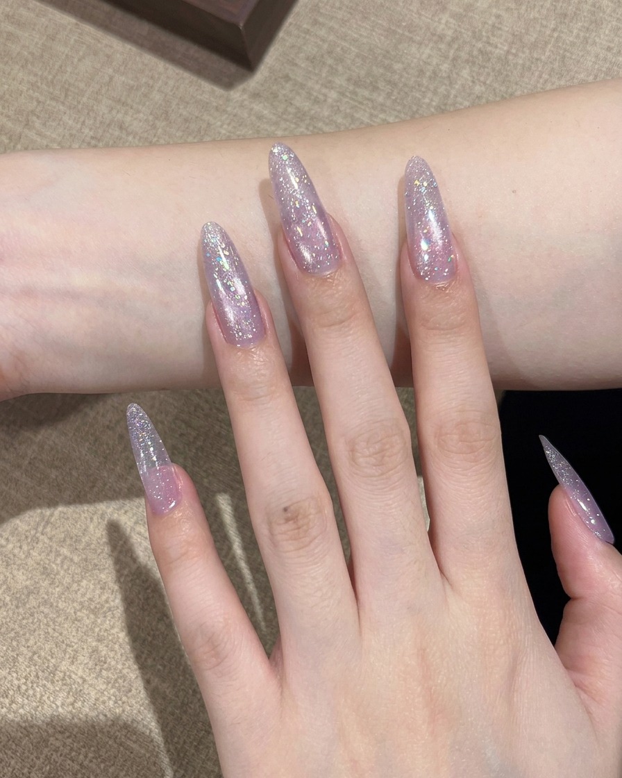 A thin detail brush applying glittery Star River polish onto the tip of the nail to begin a gradient effect.