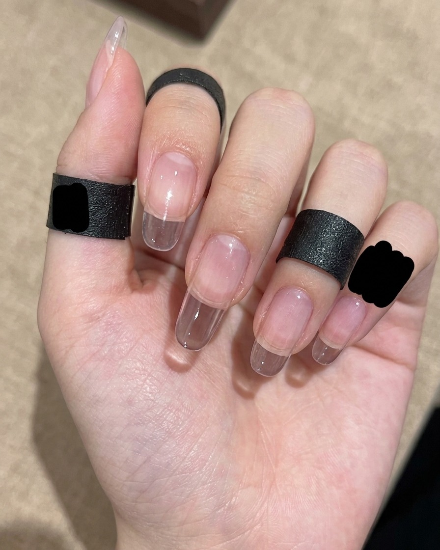 A close-up of a gradient brush being used to blend glitter gel polish from the nail tip toward the center.