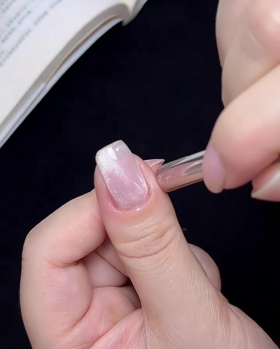 The magnet being moved in a circle around the nail to focus the cat-eye particles into a central point.