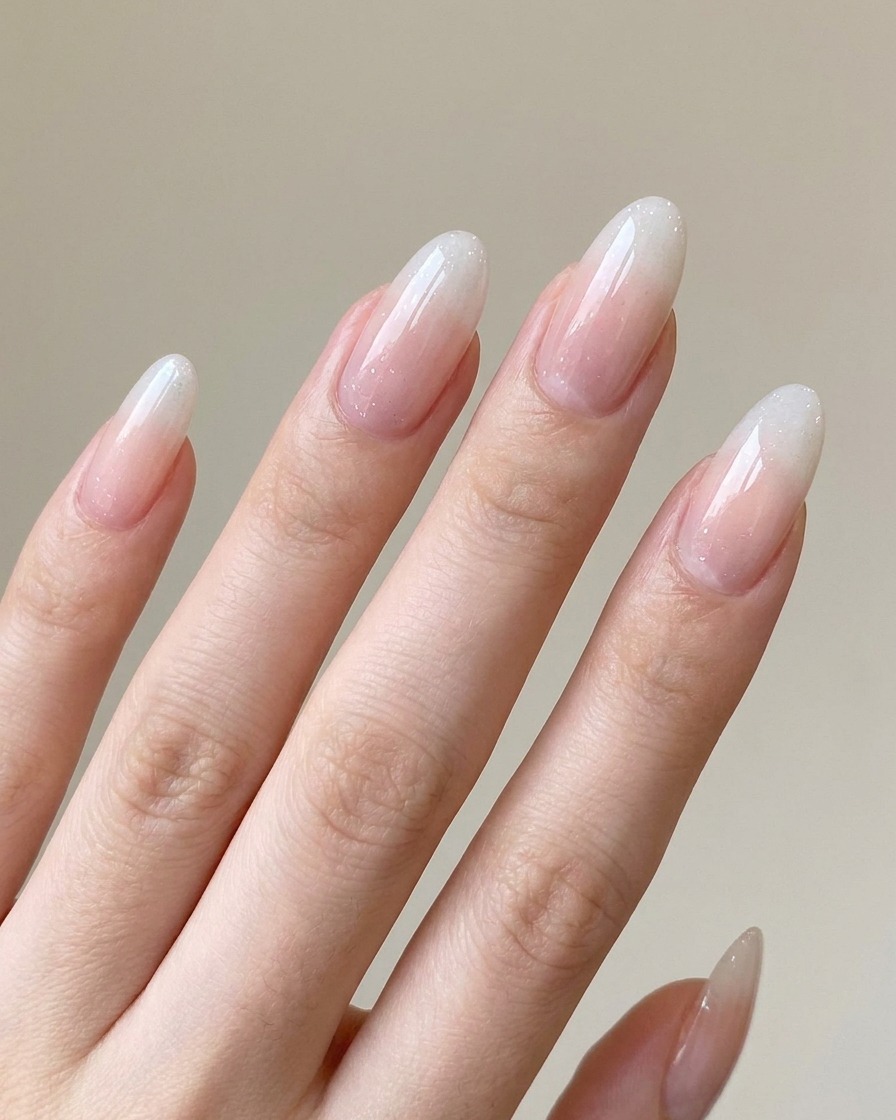 A hand resting inside a professional UV/LED nail lamp, curing the applied gel gradient.