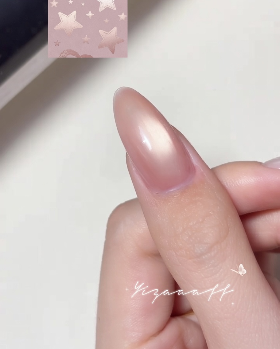 A fine liner brush drawing a white outline of a star on a polished nail surface.