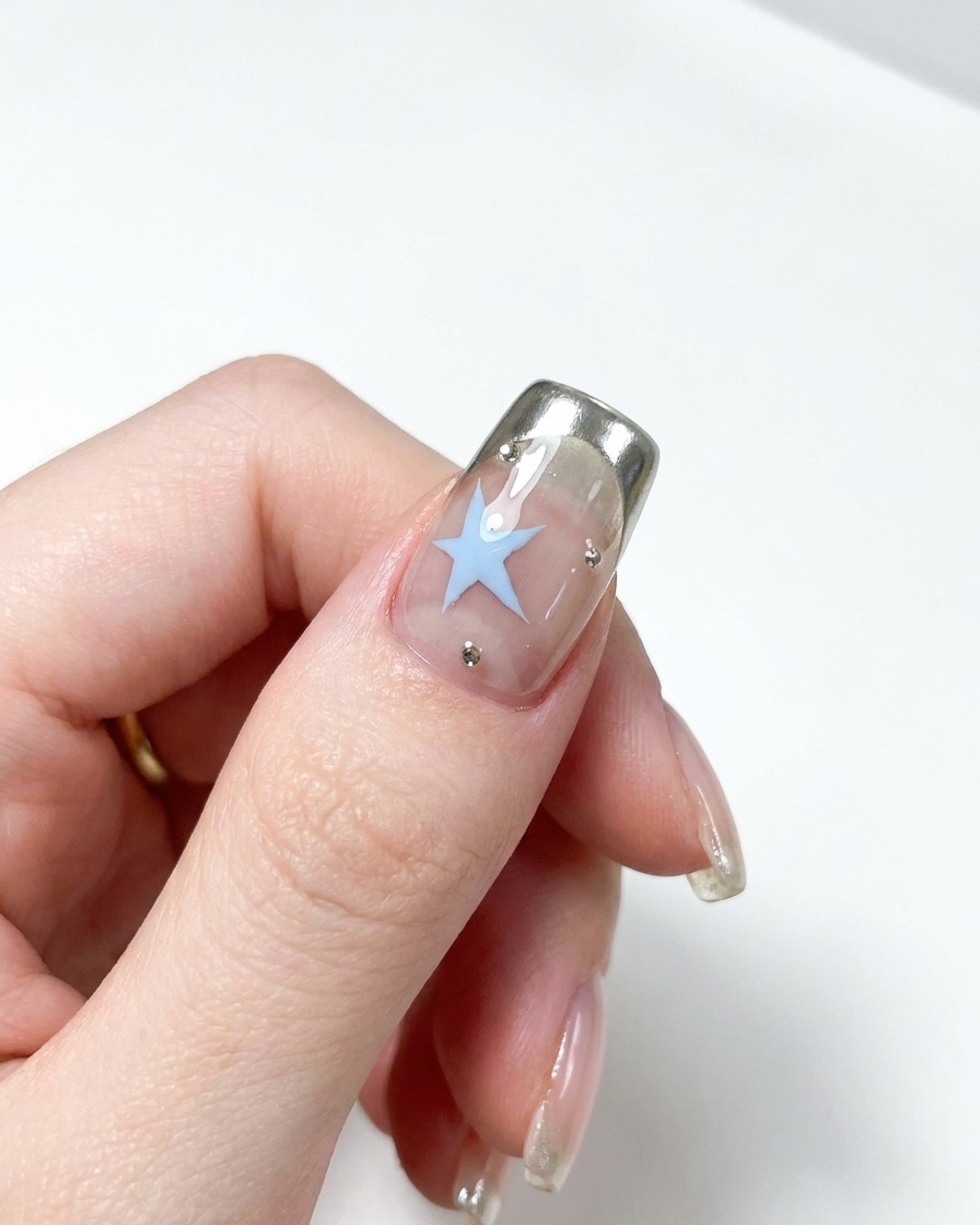 A close-up shot of a metal cuticle pusher being used to push back the cuticles on a natural nail.