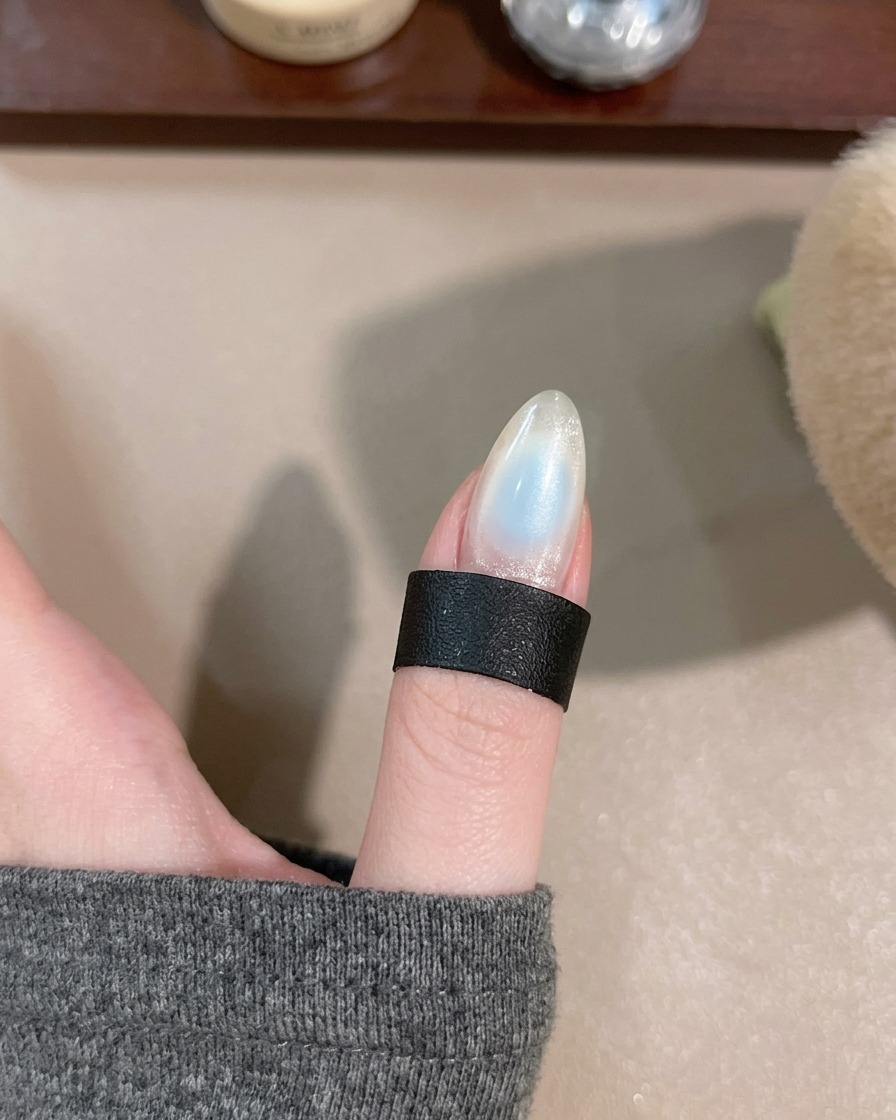 A hand placed under the portable LED lamp for curing the center gel detail.