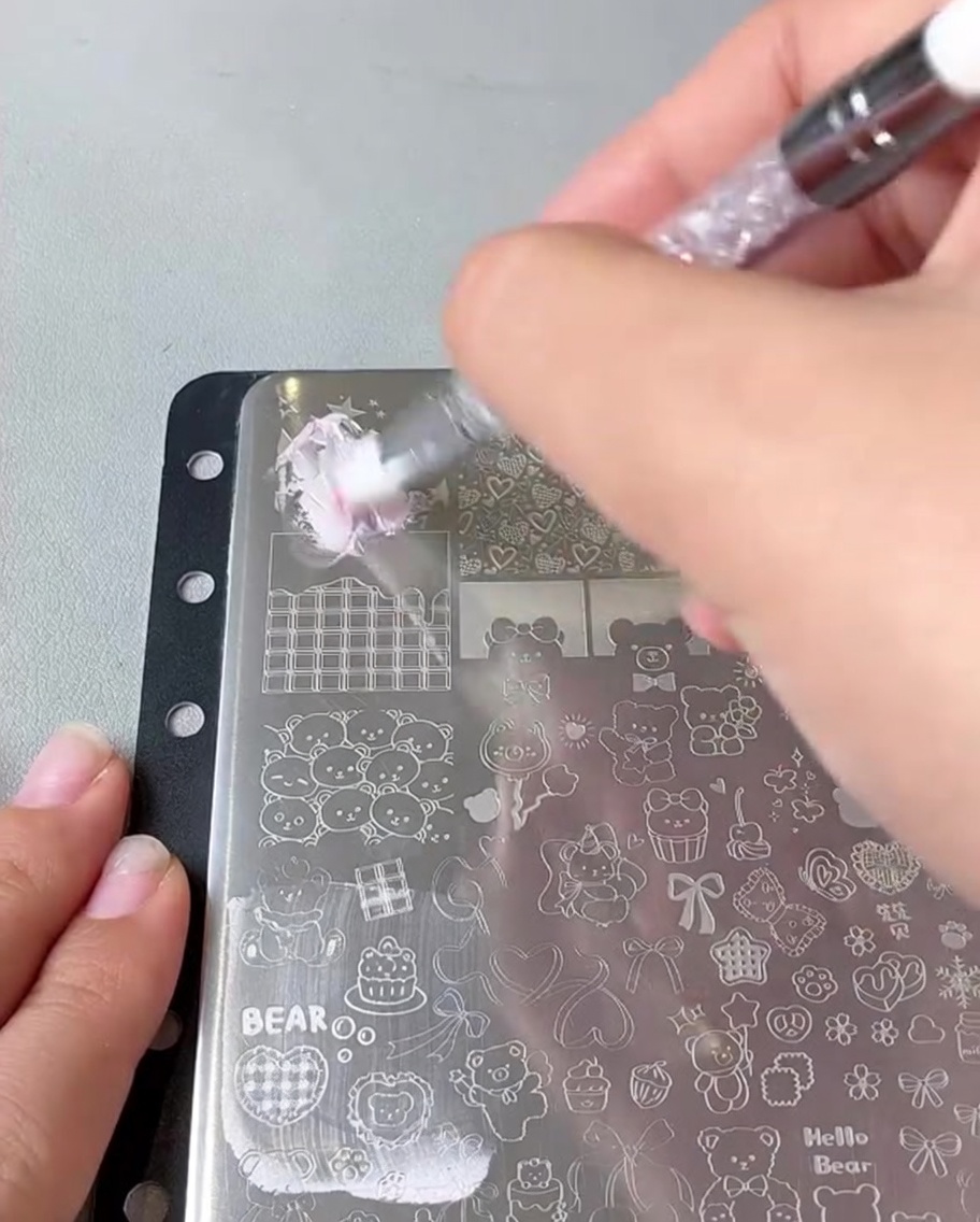 A scraper moving across a metal stamping plate.