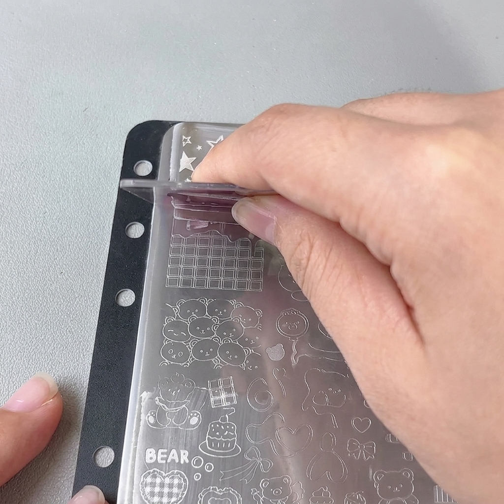 A clear jelly stamper pressed onto a metal plate design.