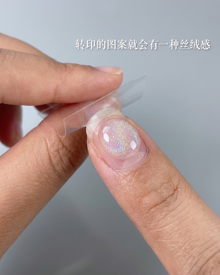 A close-up of a soft brush dusting excess powder off a finished nail design.