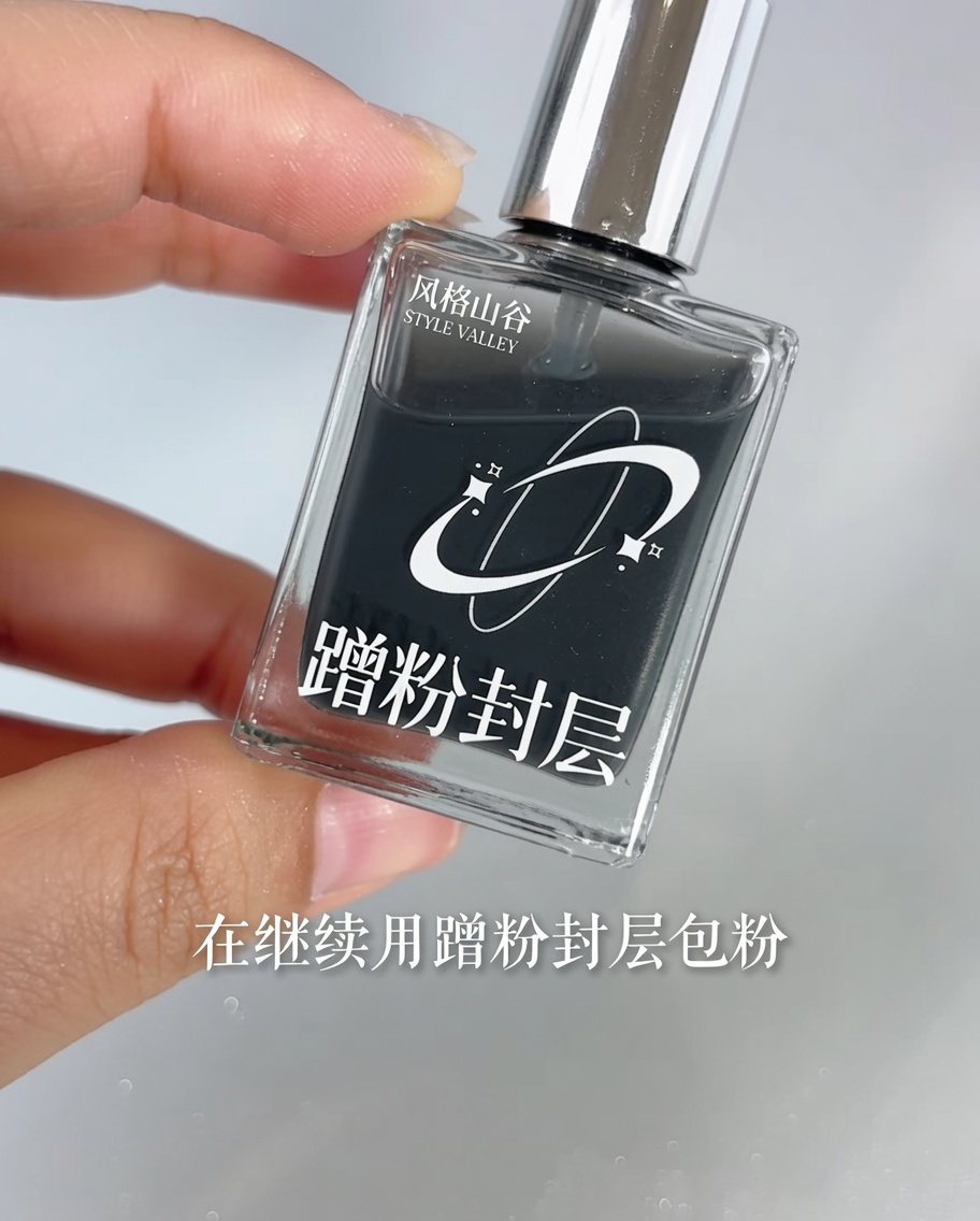 A brush applying clear top coat over a nail with a chrome mirror gradient.
