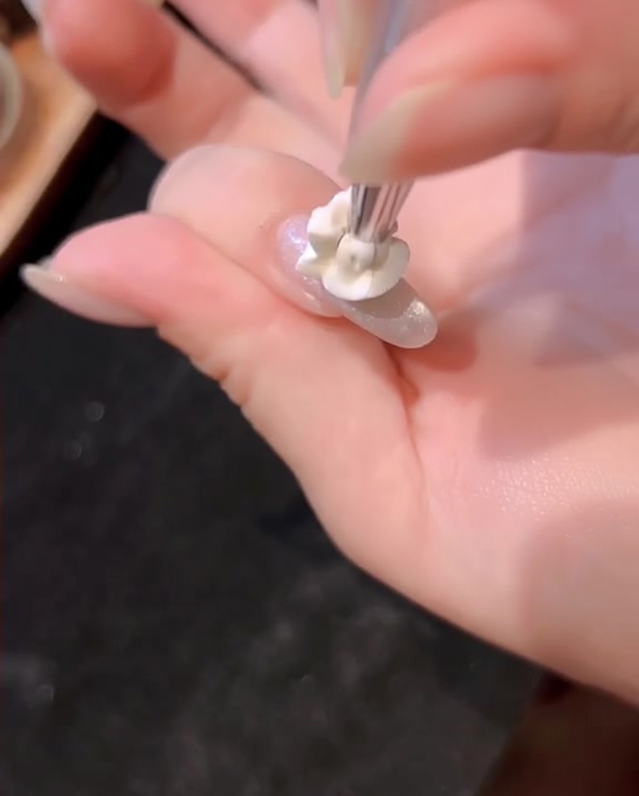 A smaller, concentrated dot of blue gel being applied on top of the existing blue layer.