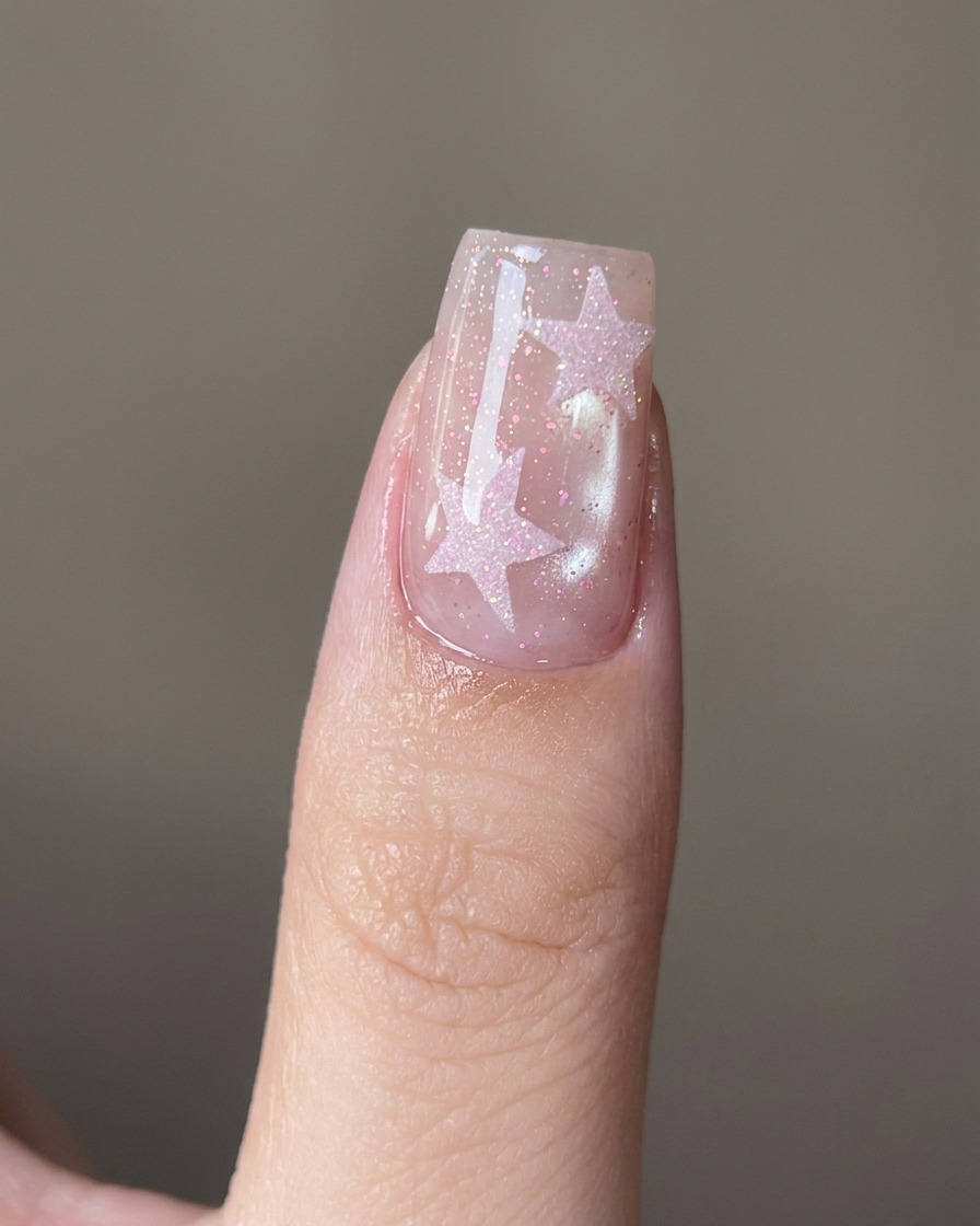 A close-up view of a metal cuticle pusher tool carefully cleaning the cuticle area on a natural nail.