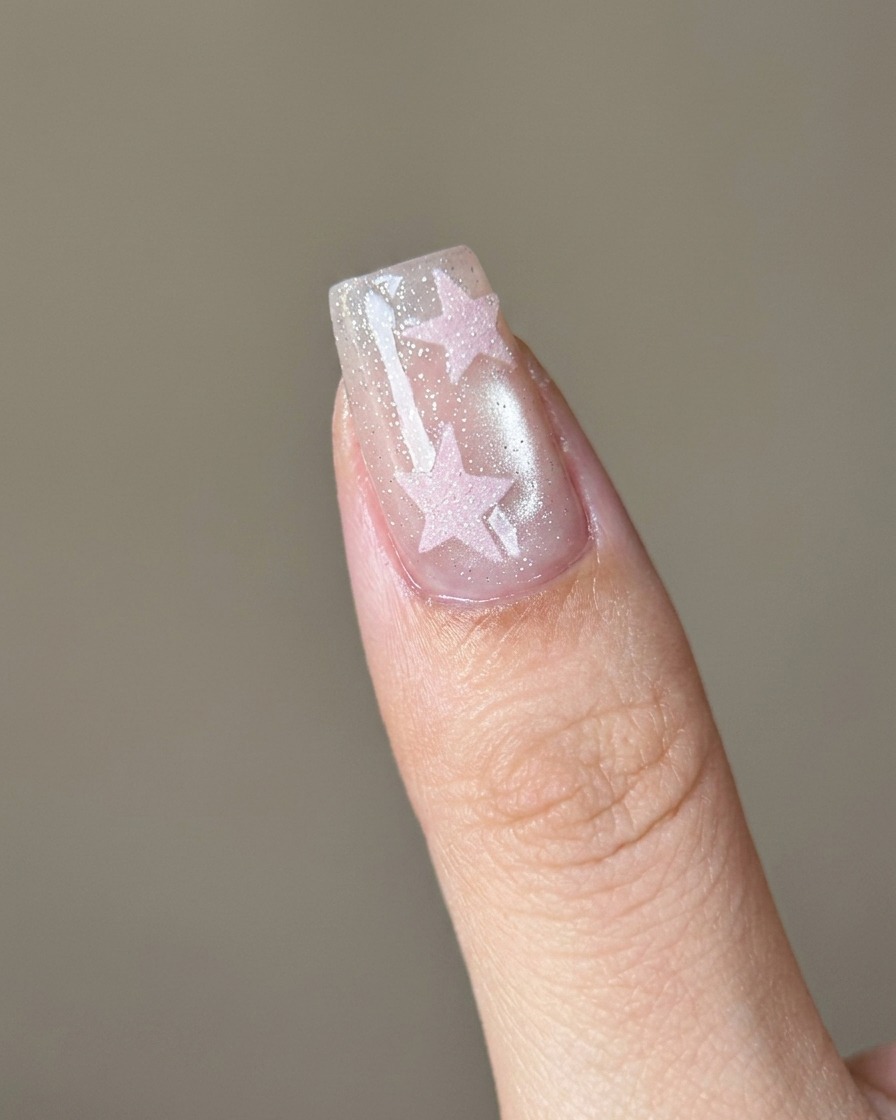 A soft brush being used to remove loose pink sugar powder from a nail.