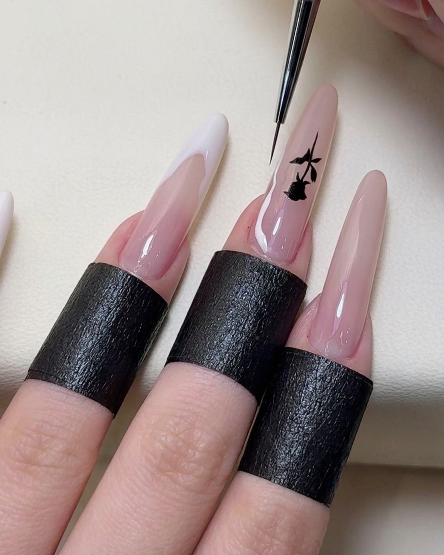 A thin nail art brush painting custom irregular shaped French tip lines in white on the ends of the nails.