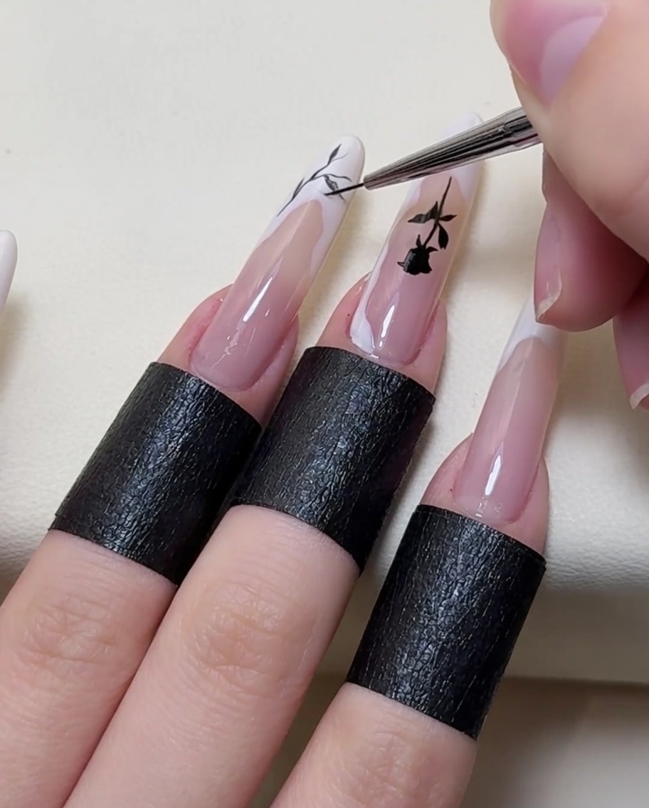 A close-up view of a brush adding further intricate branch details to the nail art.