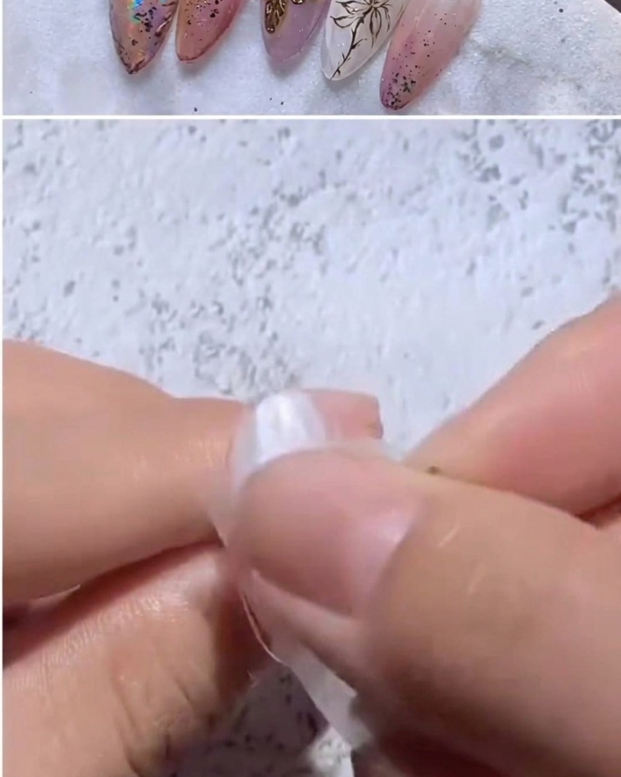 A finger pressing a piece of iridescent foil onto a nail tip.