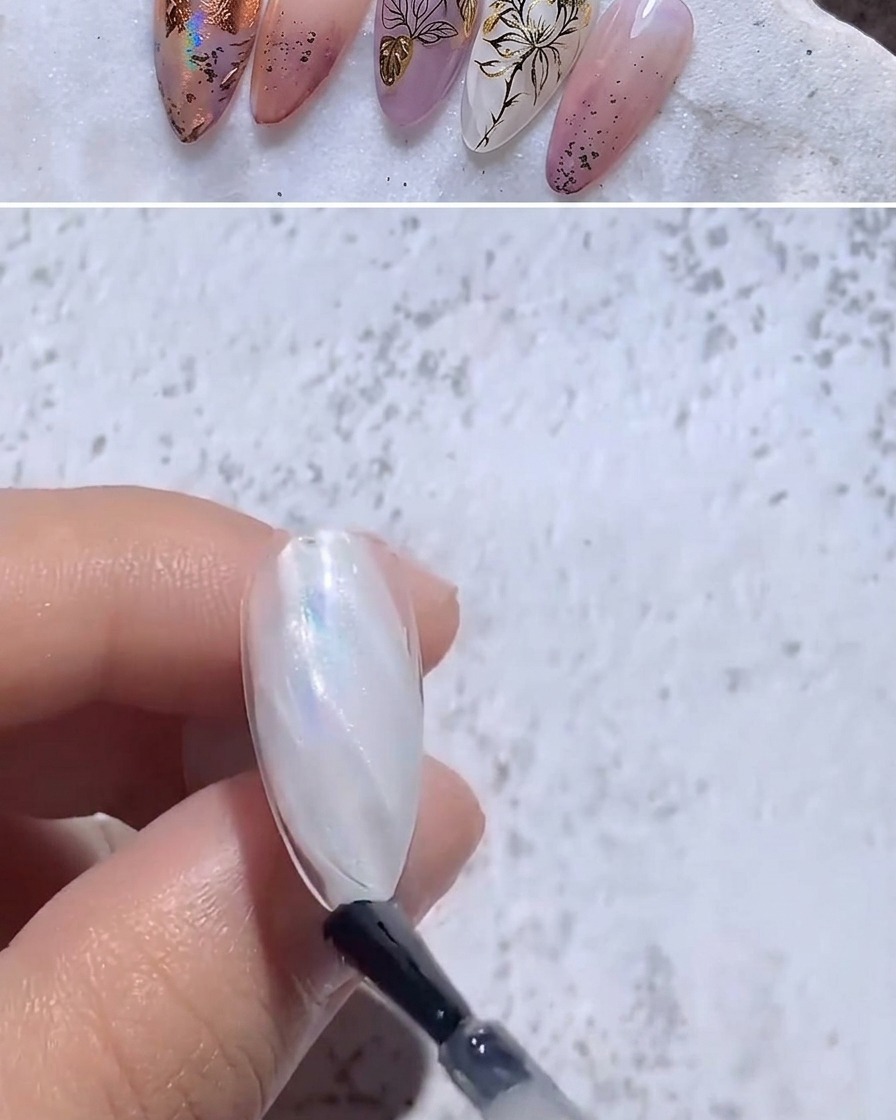 A brush applying clear glossy top coat over an iridescent foiled nail.